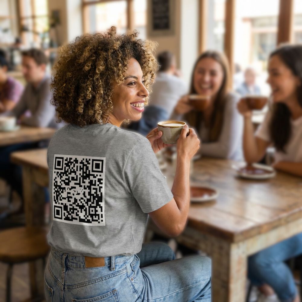 junge Frau sitzt im Café, ein QR-Code Shirt in grau