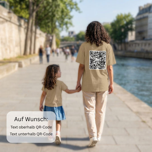 junge Frau spaziert am Fluss entlang, oversized T-Shirt mit QR-Code auf dem Rücken